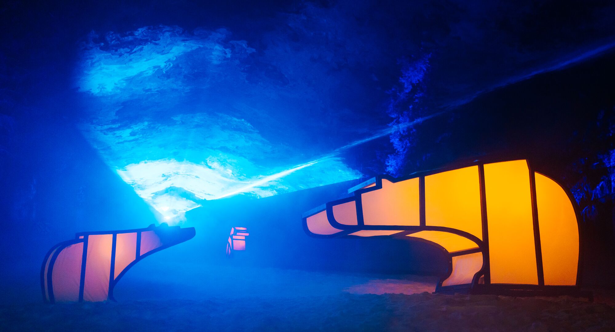 An artistic installation of two light up bears under an illuminated Northern Lights display during In Search of Christmas Spirit in Banff National Park.